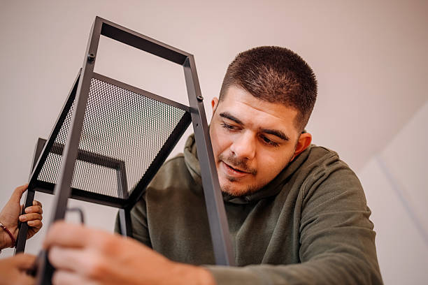istock Young people assembling bookshelf in their new home 2240824379
