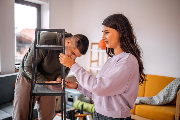 istock Young people assembling bookshelf in their new home 2240824413