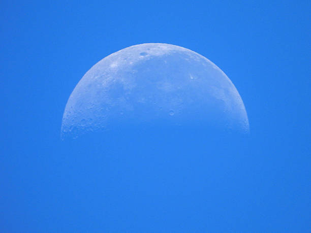 Half moon against blue sky