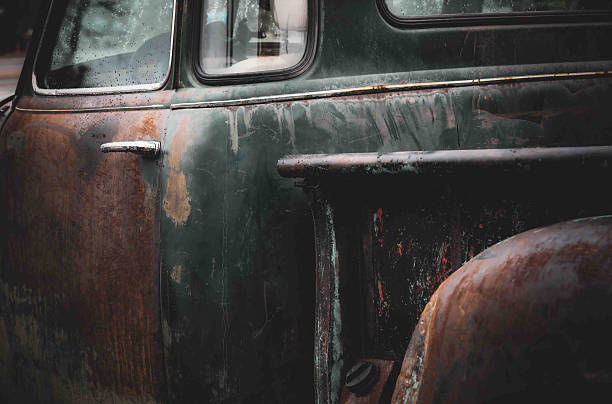 A wet, well rusted old truck, capturing the lines, surfaces and defining elements