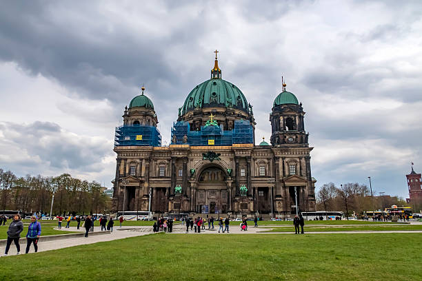 Berlin, Germany - April 13, 2019: Garden with people walking in front of the Berlin Cathedral, Berlin Cathedral in Lustgarten