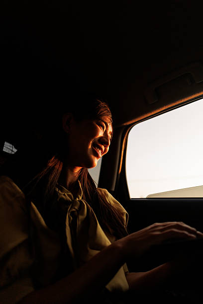 istock Beautiful Asian woman using digital tablet during car ride at sunset 2240837705
