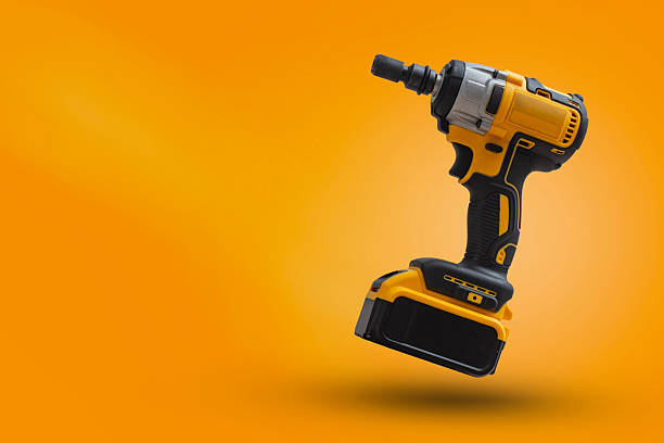istock Cordless impact wrench on yellow background with dynamic light. Electric tool for construction, car repair and DIY projects. 2240840321