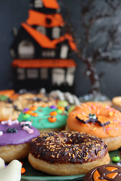 istock Image of halloween iced ring doughnuts, candy decorations / spooky festive cakes, creative dessert treats, colorful autumn sweets 2240841102