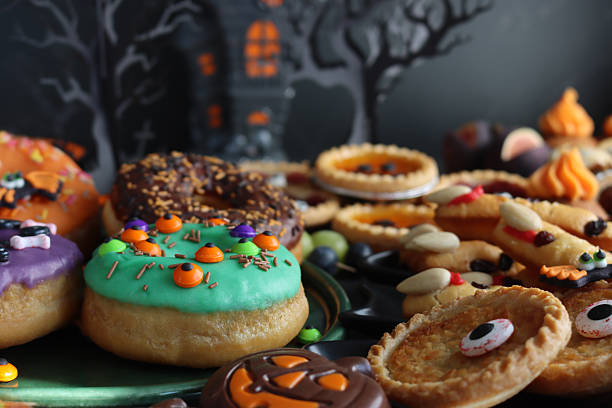 istock Image of halloween iced ring doughnuts, candy toppings / spooky festive cakes, creative dessert treats, colorful autumn sweets 2240841364