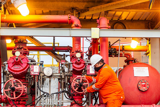 istock Industrial worker operates a red valve on a fire suppression system for safety regulations indoors 2240841367