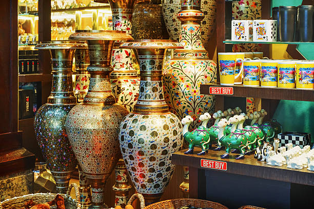 Colorful vases and handcrafted souvenirs fill the shelves of a busy retail shop in Dubai's vibrant market scene.