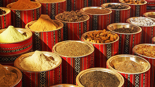 Colorful spices are beautifully displayed in containers at a vibrant Dubai market, showcasing local culture.