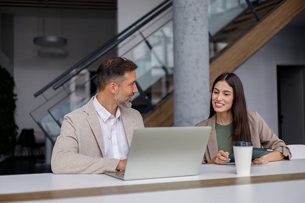 istock Business colleagues collaborating on laptop in modern office, discussing work and sharing ideas 2240844496