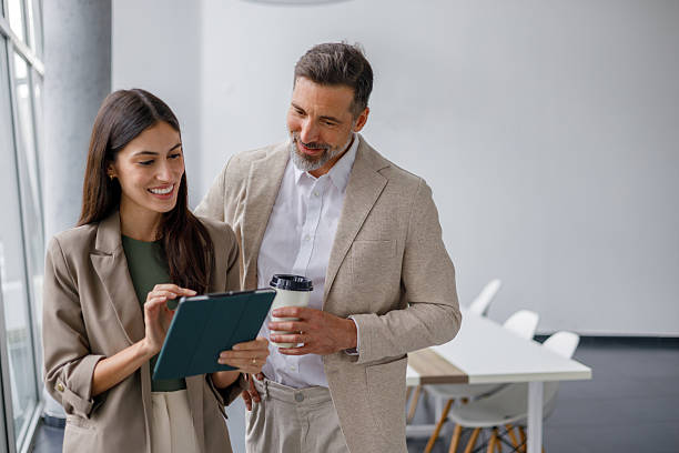 istock Business colleagues collaborating on digital tablet, discussing project during informal meeting in modern office space 2240846038