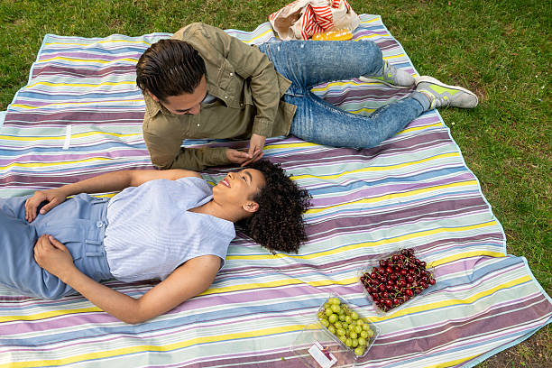 istock Interracial couple having romantic picnic in park 2240850561