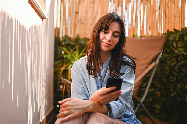istock Woman relaxing outdoors browsing social media on smartphone 2240852793