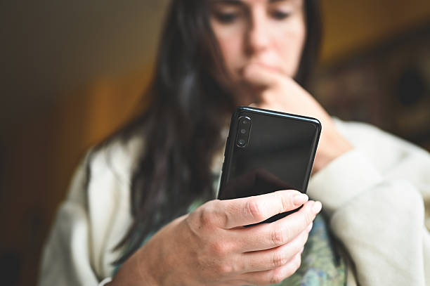 istock Woman deeply focused browsing content on smartphone 2240852884