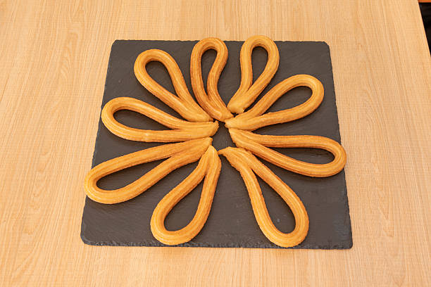 Serving of churros cooked in Madrid style for breakfast on a black slate base