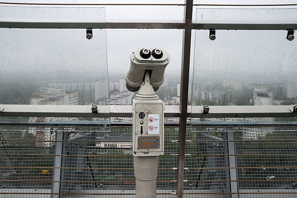 Minsk, Belarus - May 07, 2015 - Binocular telescope overlooking foggy cityscape from observation deck.