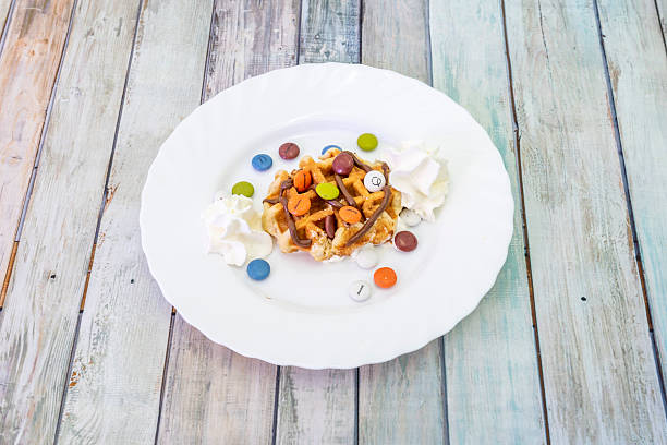 Crispy waffle-shaped cake of Belgian origin that is cooked between two dishes, to this was added a lot of cream, chocolate syrup and chocolate sprinkles