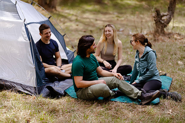 istock Friends enjoy a relaxing camping experience in the great outdoors, sharing stories and laughter under a clear blue sky 2240865227