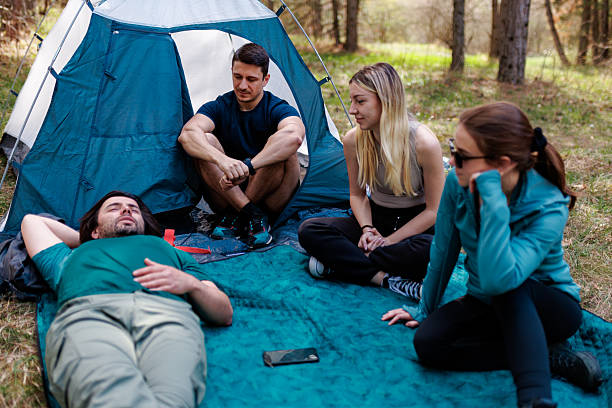 istock Group of friends enjoying a relaxed camping experience in a forest setting while sharing stories and laughter during a sunny afternoon 2240865230