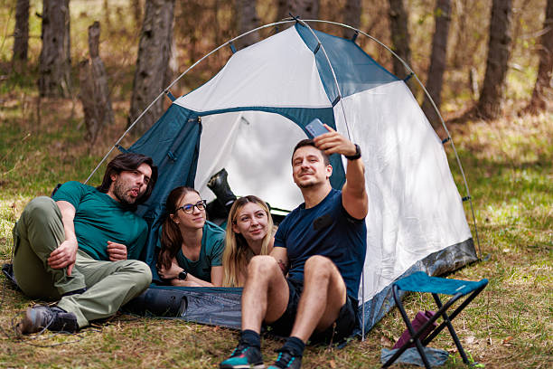 istock Camping adventure with friends enjoying moments inside a tent in a serene forest setting during a sunny day 2240865235