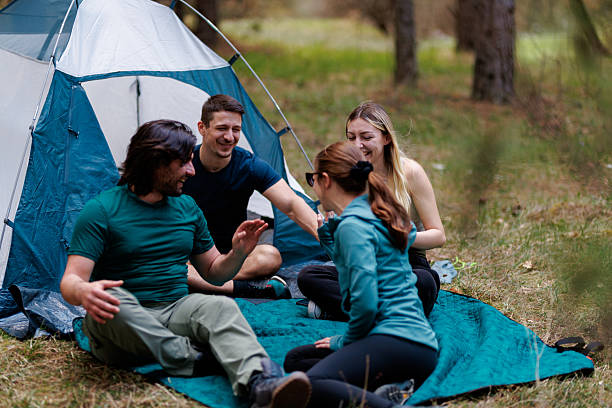 istock Friends enjoying quality time around a camping tent in nature during the day while sharing laughter and stories together in a serene outdoor setting 2240865236