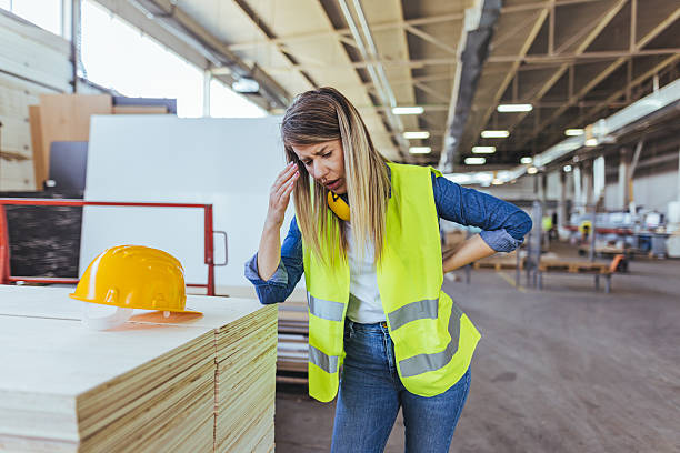 istock Construction Worker Displays Fatigue in a Warehouse Environment Holding Safety Gear 2240865402