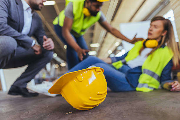 istock Team Assisting Injured Worker in Industrial Setting with Safety Equipment 2240865425