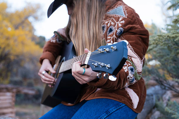 istock Cowgirl Playing Guitar Outdoors in Autumn 2240867945