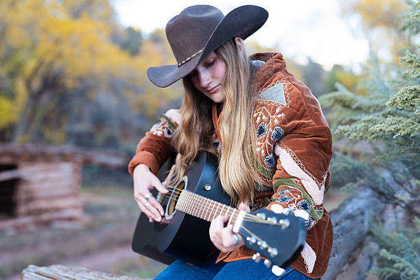 istock Cowgirl Playing Guitar Outdoors in Autumn 2240868145