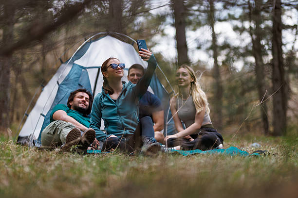istock Friends enjoying a camping trip outdoors while taking a selfie near their tent on a sunny afternoon surrounded by nature 2240872312