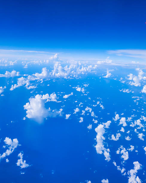 istock Aerial view from airplane window at high altitude covered with white puffy cumulus clouds. Deep blue and contrast sky and clouds 2240886124