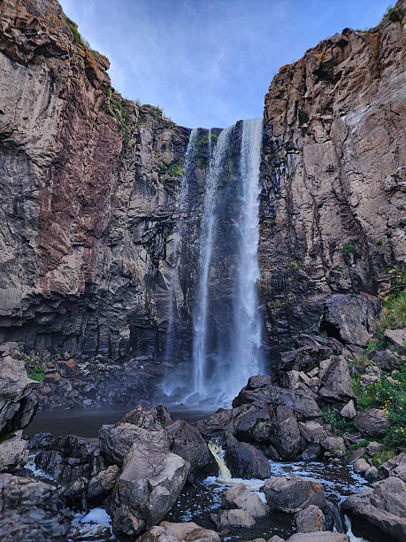 istock View of a waterfall running into a river with stone cliffs in the high Andean valleys 2240888230