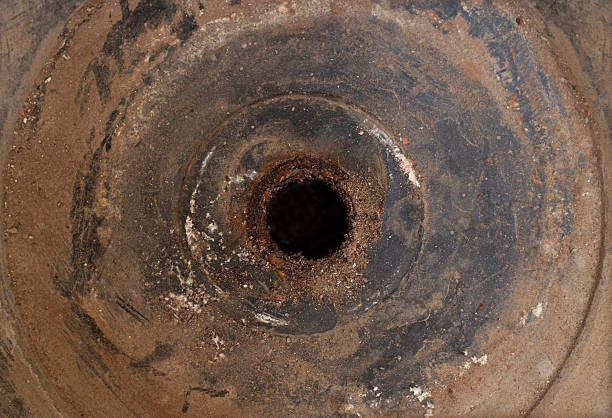 Old style ancient dirty messy full frame metallic iron circle with a circular hole in middle covered in soil dirt, a gym weight, old fashioned wheel, rusty rustic metal plate.