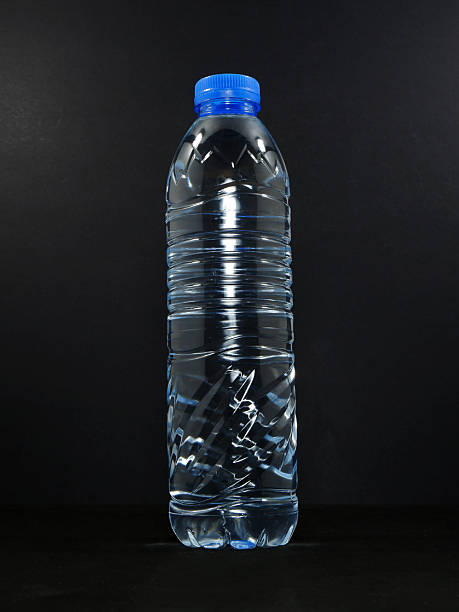 istock Drinking water bottle isolated on black background close-up view 2240897268