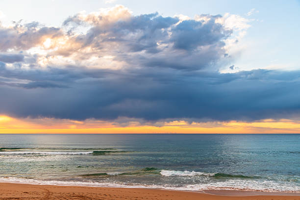 istock Winter sunrise by the sea shore with rain clouds 2240901137