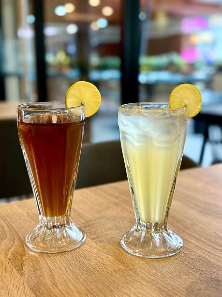 the cup of iced tea on the table is half full
