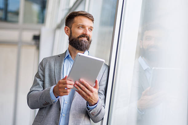 istock Businessman enjoying success, holding tablet in office 2240905946