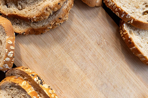 Freshly baked multigrain bread slices on wooden table in natural light. Perfect for healthy lifestyle, breakfast menu, or organic bakery concept.
