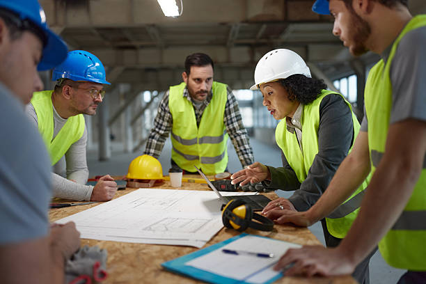 istock Female civil engineer having a meeting with manual workers at construction site. 2240908440