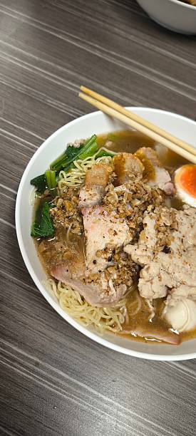 istock Chinese-style noodle soup on a wooden table 2240912256