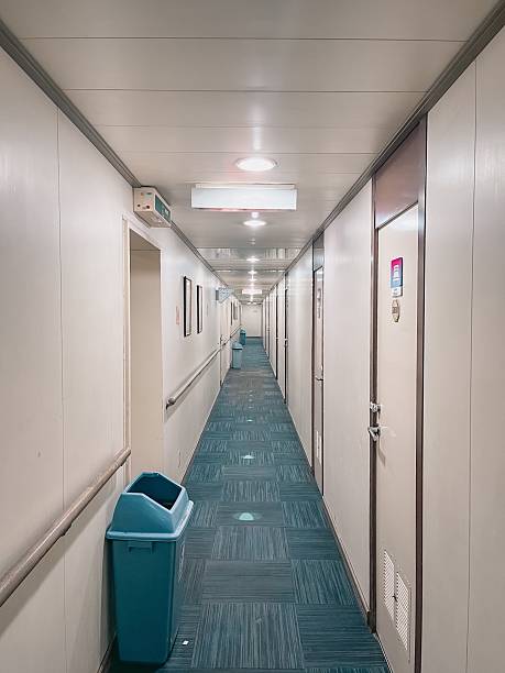 Long Corridor With Doors, Lights, And Blue Trash Bin In Quiet Hallway