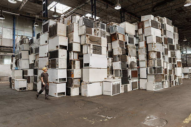 istock Worker walking through recycling plant with old refrigerators 2240914175