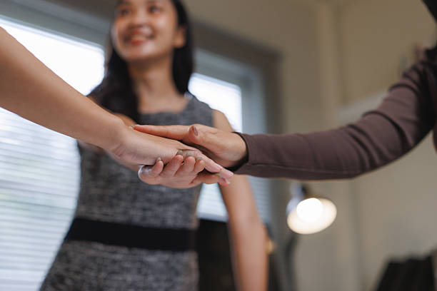 istock Businesswomen stacking hands demonstrating unity and collaboration 2240914714