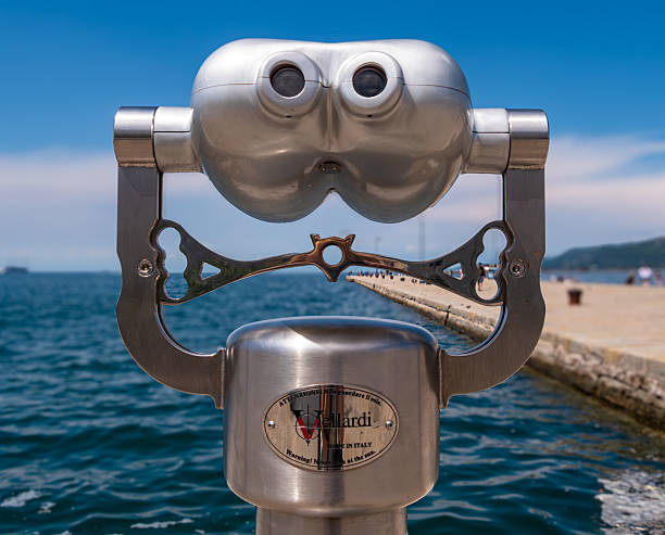 Trieste, Italy - 1 August 2025: Coin-operated binoculars in Trieste overlooking a scenic waterfront.