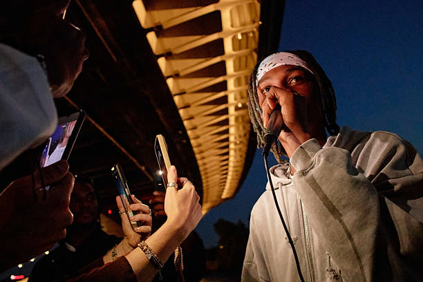 istock Young Black Man Performing Rap Music Outdoors While Audience Recording Video 2240921638