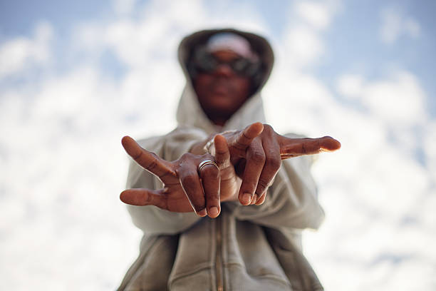istock Young Adult Black Man Gesturing with Hands Outdoors Against Sky 2240926137