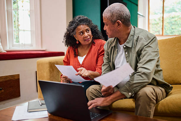 istock Concerned Senior Black Couple Discussing Financial Documents at Home 2240927303
