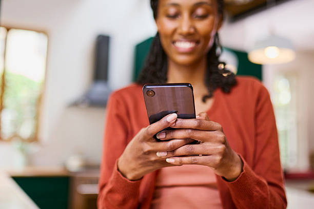 istock Close-up of Happy Black Woman's Hands Using Smartphone at Home 2240927309
