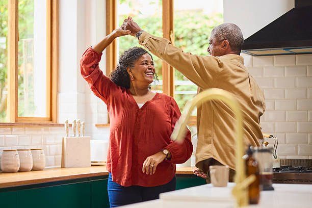 istock Senior Black Couple Happily Dancing a Spin in the Kitchen 2240927380