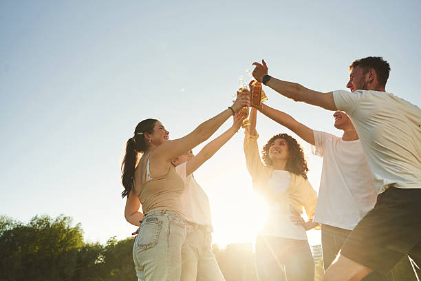 istock Party time, celebration. People are celebrating by cheering with beer bottles 2240929824