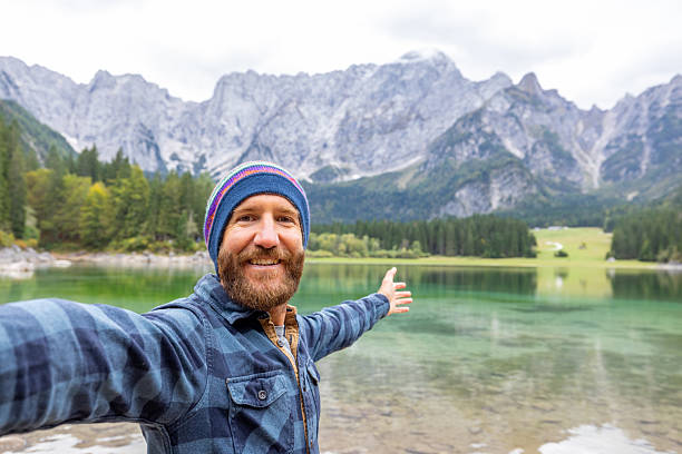 istock Man Taking Selfie at Mountain Lake Shore 2240930633